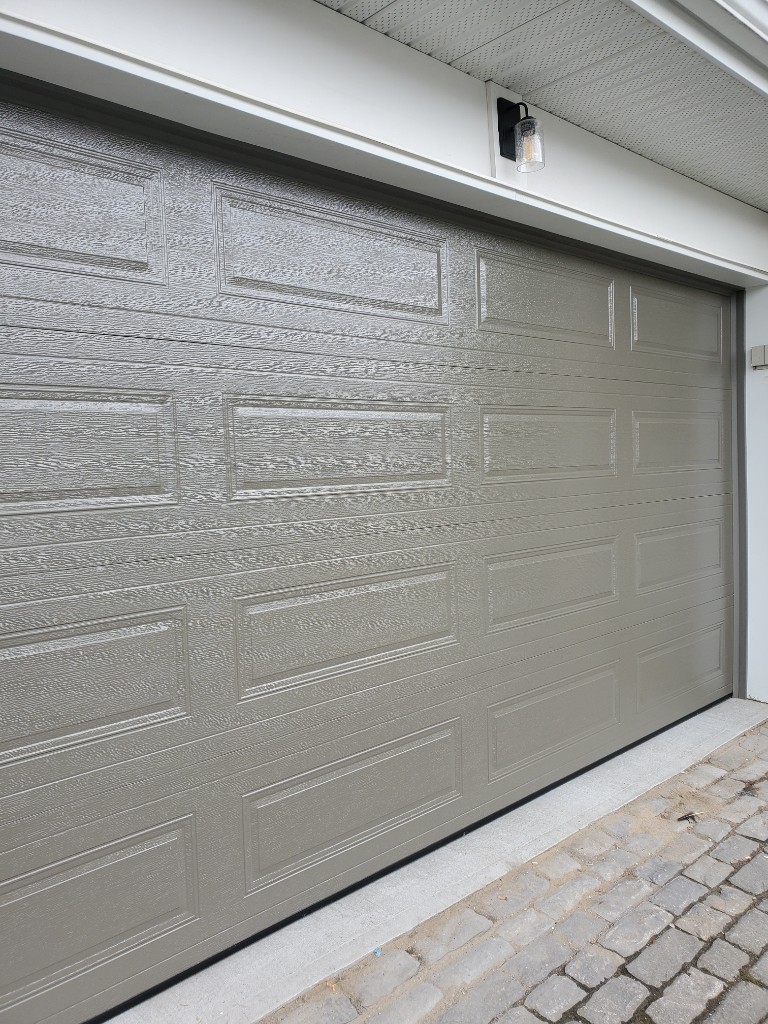 Taupe wood-grain garage door with bottom seal — repair vs replace in Ottawa