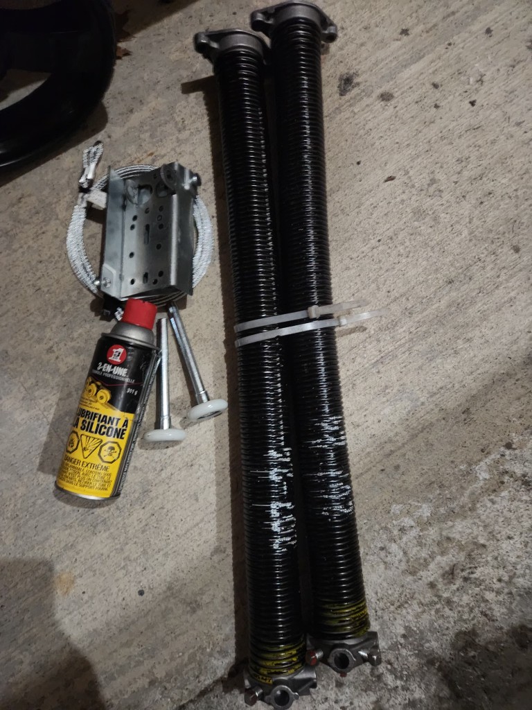 Garage door springs, cables, and hardware laid out for repair — Ottawa pricing guide